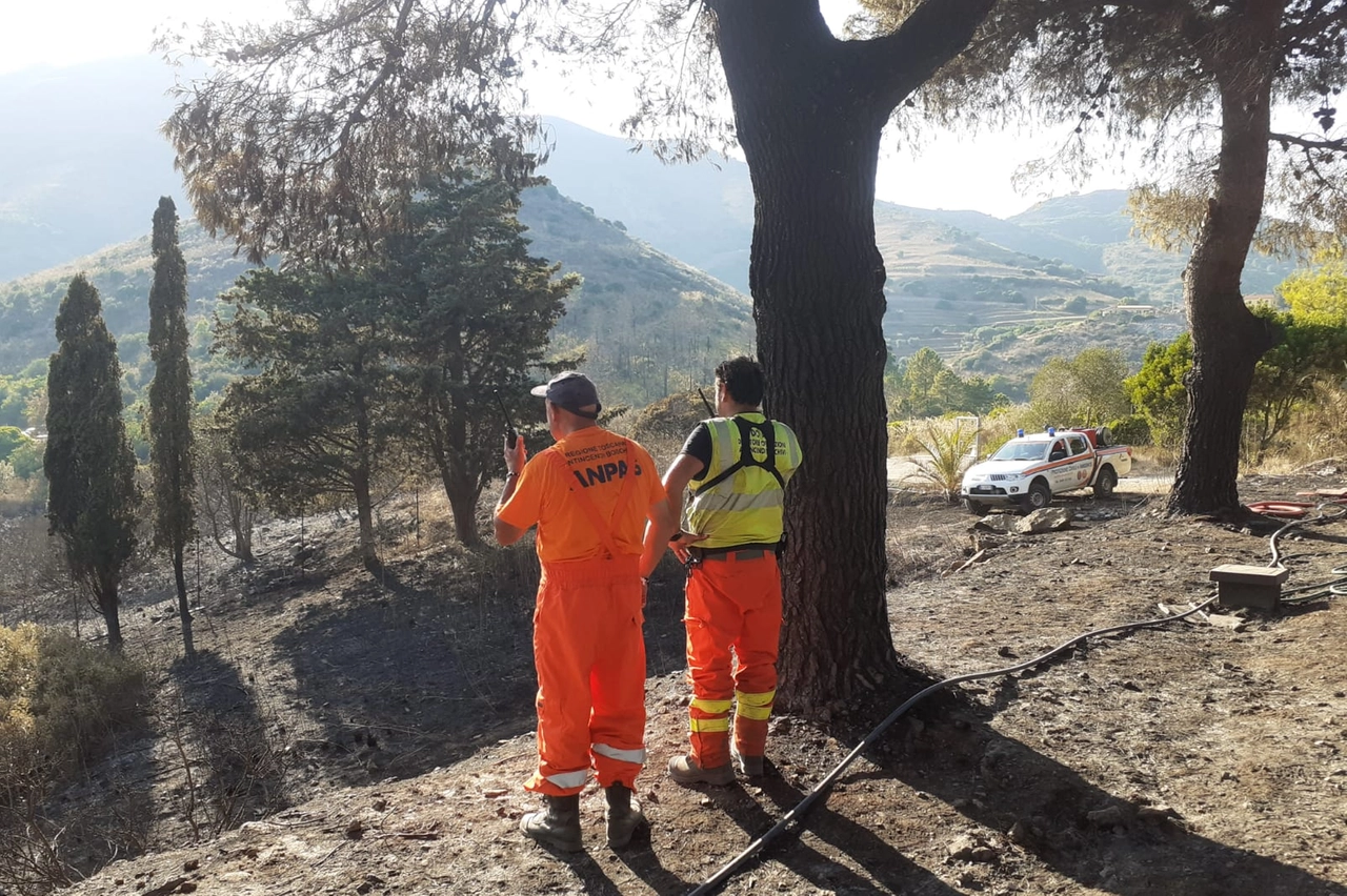 Due uomini del servizio antincendio sul luogo del rogo